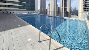Ein Pool auf dem Dach mit Blick auf hohe Gebäude.