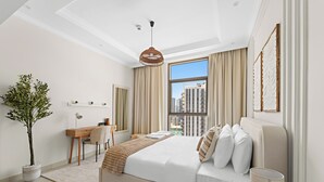 A modern hotel room with a large bed, a desk, a chair, a potted plant, and a view of the city. - Silkhaus Reflection Tower (Abu Dhabi)