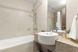 Ein modernes Badezimmer mit einer Badewanne, einem Waschbecken und einem Spiegel.