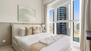 Una habitación de hotel moderna con una cama grande, vistas a la ciudad y una decoración minimalista.