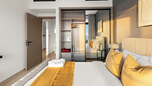Ett modernt hotellrum med en stor säng, en rymlig klädkammare och utsikt över staden.