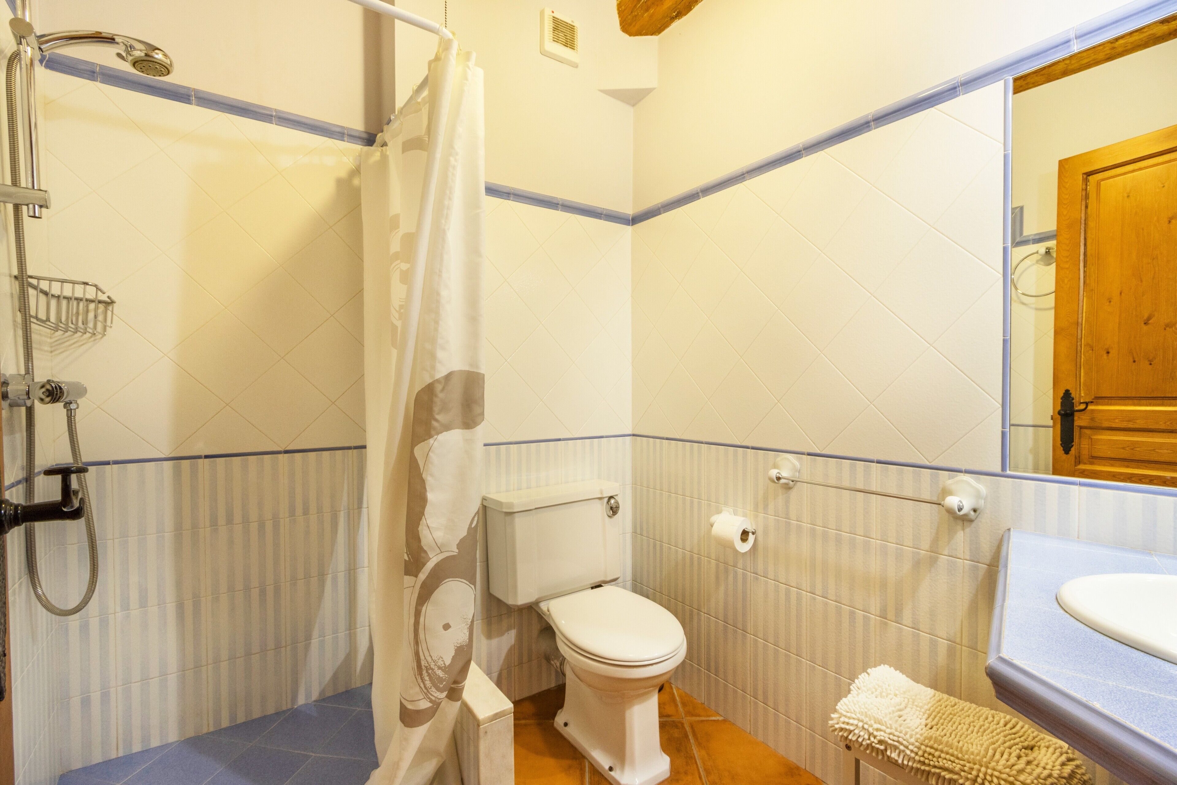 A bathroom with a shower, toilet, and sink.