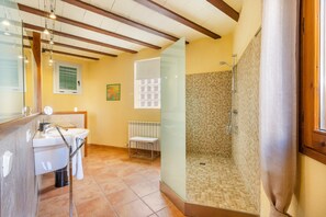 Een badkamer met wastafel, spiegel en douche.