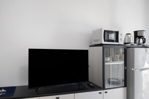 A kitchenette with a microwave, coffee maker, and a TV on a black countertop. - Apartment 'Le Morelle 2' with Balcony and Wi-Fi (Albenga)