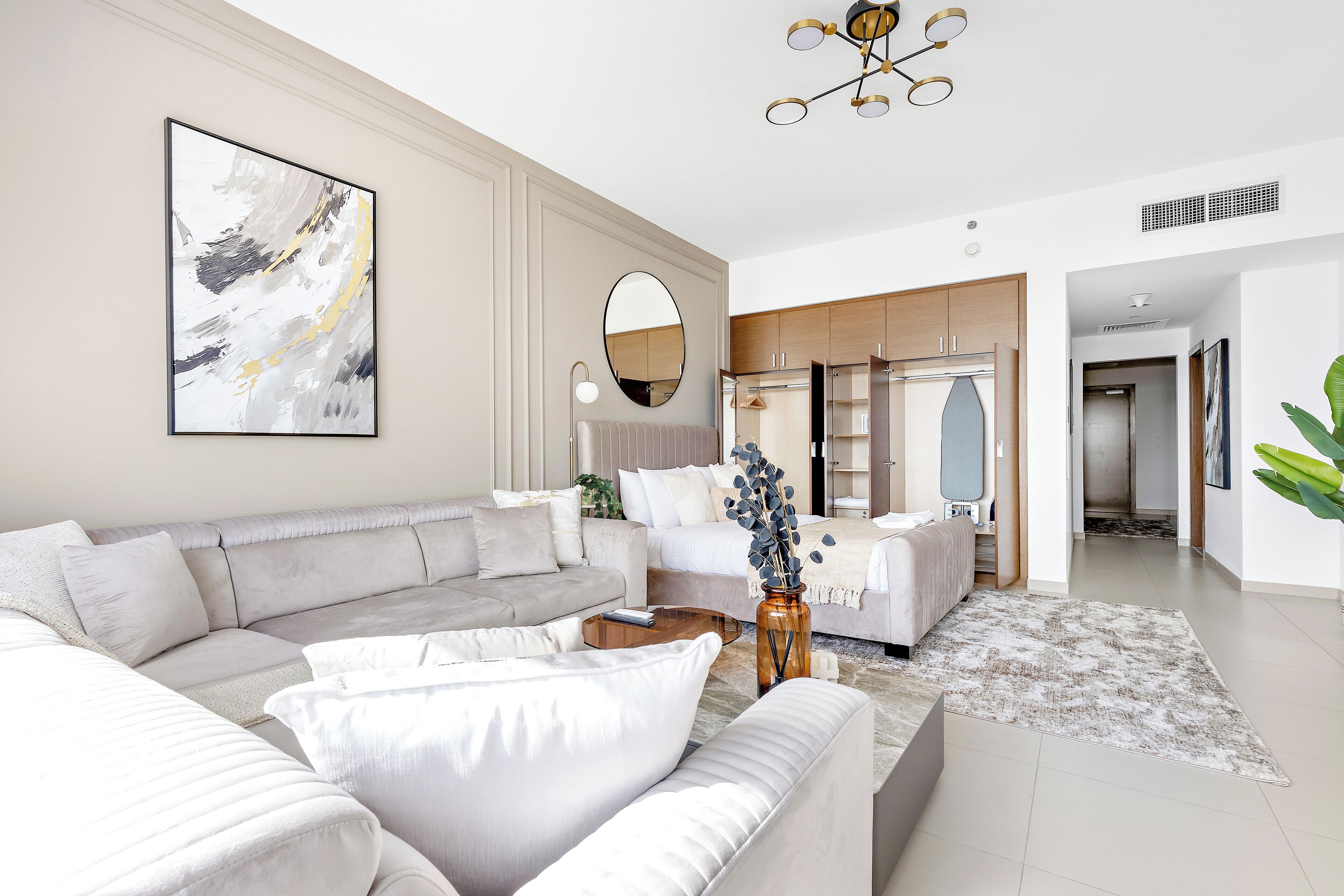 A modern living room with a sectional sofa, a coffee table, and a large abstract painting.