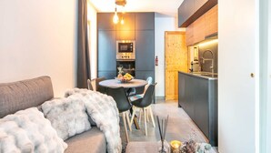 A compact living space with a dining area, kitchenette, and a cozy seating area with a fur throw. - Apartment in Saint-Sorlin with Mountain Views (Saint-Sorlin-d´Arves)