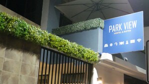A building entrance with a sign reading "PARK VIEW HOSTEL & SUITES". - Park View Hostel & Suites (Manta)
