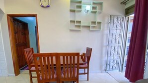 Un comedor con una mesa y sillas de madera, un reloj en la pared y una lámpara decorativa.