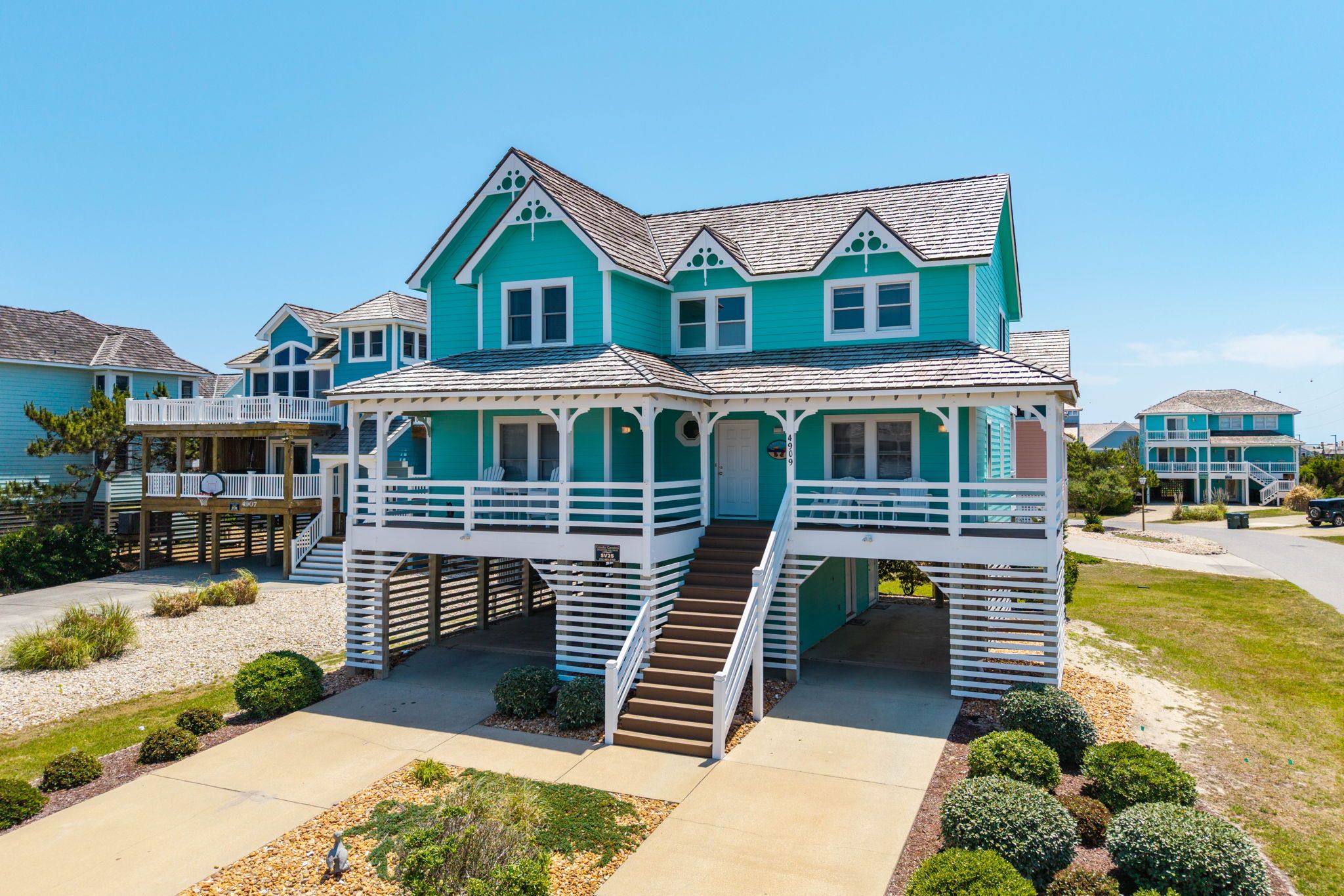 A two-story house with a porch and a staircase leading to the entrance.