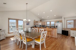 Une cuisine spacieuse dotée de meubles en bois, d’un îlot central et d’un coin repas avec une table et des chaises.
