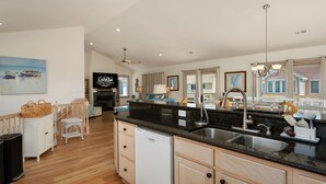A spacious kitchen with a large island, built-in dishwasher, and a modern faucet. - A Bbitt Beachy: Oceanside, Hot Tub, Community Pool, Easy Beach Access (Nags Head)