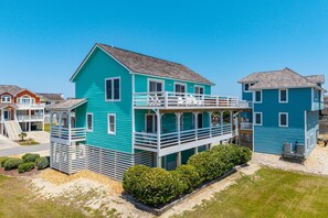 A two-story house with a balcony, a porch, and a small deck. - A Bbitt Beachy: Oceanside, Hot Tub, Community Pool, Easy Beach Access (Nags Head)