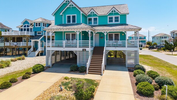 A two-story house with a covered porch and a staircase leading to the entrance. - A Bbitt Beachy: Oceanside, Hot Tub, Community Pool, Easy Beach Access (Nags Head)