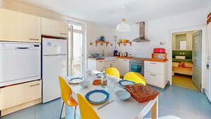 A compact kitchen with white cabinets, a built-in oven, and a dining area with a table set for two.