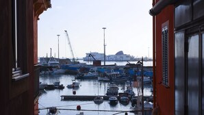 A harbor with various boats docked, a large ship in the background, and a building with a sign reading 'CROPPER TOURIST'.