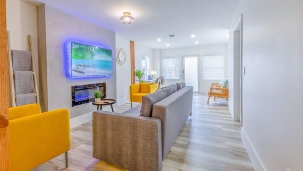 A modern living room with a flat-screen TV, a fireplace, and a sofa. - 8Guest, 5 minutes to everything in Miami (Miami)
