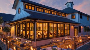 Ein Restaurant mit Außenbereich, großen Fenstern und einer überdachten Terrasse.