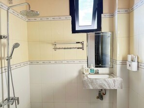 A bathroom with a shower, a sink, a mirror, and a window. - Doi Ngoai Bien Phong SPA Hotel (Buon Ma Thuot)