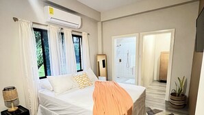A bedroom with a bed, a bedside table, a lamp, and a window with curtains. - 2-bedroom villa with WiFi, AC in St. Lucia-Beach, Falls,Pitons, Mud Bath (Laborie)