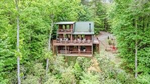A two-story wooden cabin surrounded by dense forest. - Luxury Pet-Friendly Mountain Cabin - Hot Tub - Views - 20 Min to Blue Ridge (Cherry Log)