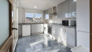 A modern kitchen with white cabinets, a built-in oven, microwave, and dishwasher. - COLL GROC - Nice villa with shared swimming pool in Grau i Platja (Gandia)