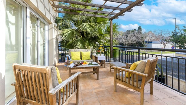 A patio with wooden furniture, a table with fruits, and a palm tree. - COLL GROC - Nice villa with shared swimming pool in Grau i Platja (Gandia)