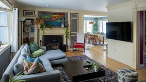 A living room with a fireplace, a sofa, a coffee table, and a TV.