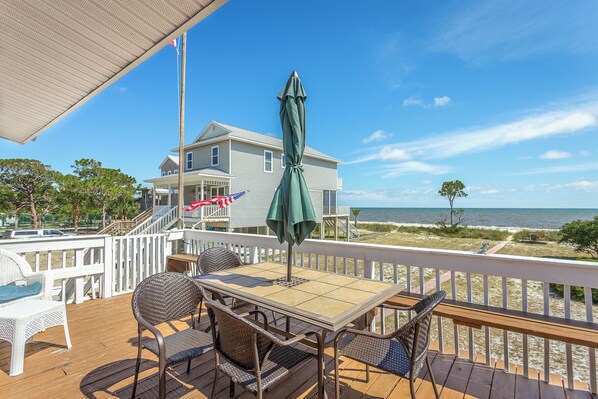 A deck with a table and chairs, overlooking a beach and a house. - 🌴 Prime Summer Availability | Relax, Unplug & Enjoy the Coast (Alligator Point)
