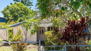 A house surrounded by lush greenery, including various plants and trees. - Escape from it all at Crooked Cottage, your peaceful retreat nestled in the heart of Nambucca Heads. (Nambucca Heads)