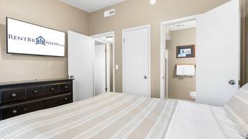A bedroom with a bed, dresser, and a framed sign on the wall.