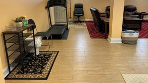 A home gym with a treadmill, exercise chair, and a shoe rack. - Home in Washington DC, 2 bedrooms, 4 beds, 2 baths,sleeping 5 & free parking. (Washington)