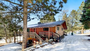 A cabin with a wooden deck and stairs leading to a porch. - Charming Mountain Escape near Lake Cascade (Cascade)