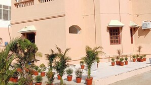 A hotel named 'HOTEL YUBRAJ' with a modern architectural design, featuring balconies and potted plants in the foreground. - Hotel Yubraj (Puri)