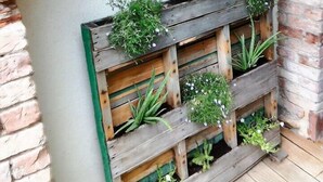 Un mur de briques rustique agrémenté d’une jardinière en bois remplie de différentes plantes.