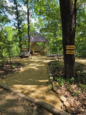 Ein Campingplatz mit Zelt, Picknicktischen und einem Schild, das einen privaten Campingplatz kennzeichnet.