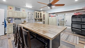 A modern kitchen with a central island, wooden cabinets, and a ceiling fan. -  Luxury Country Stay - Indoor heated pool, Spa, Art Studio, Breakfast, Hot Tub (Chipley)