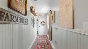 Un couloir orné d’une enseigne évoquant une ferme, d’une guirlande décorative et d’un tapis à motifs.