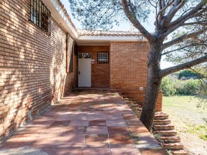 Un bâtiment en briques avec un chemin piétonnier dallé menant à une porte.