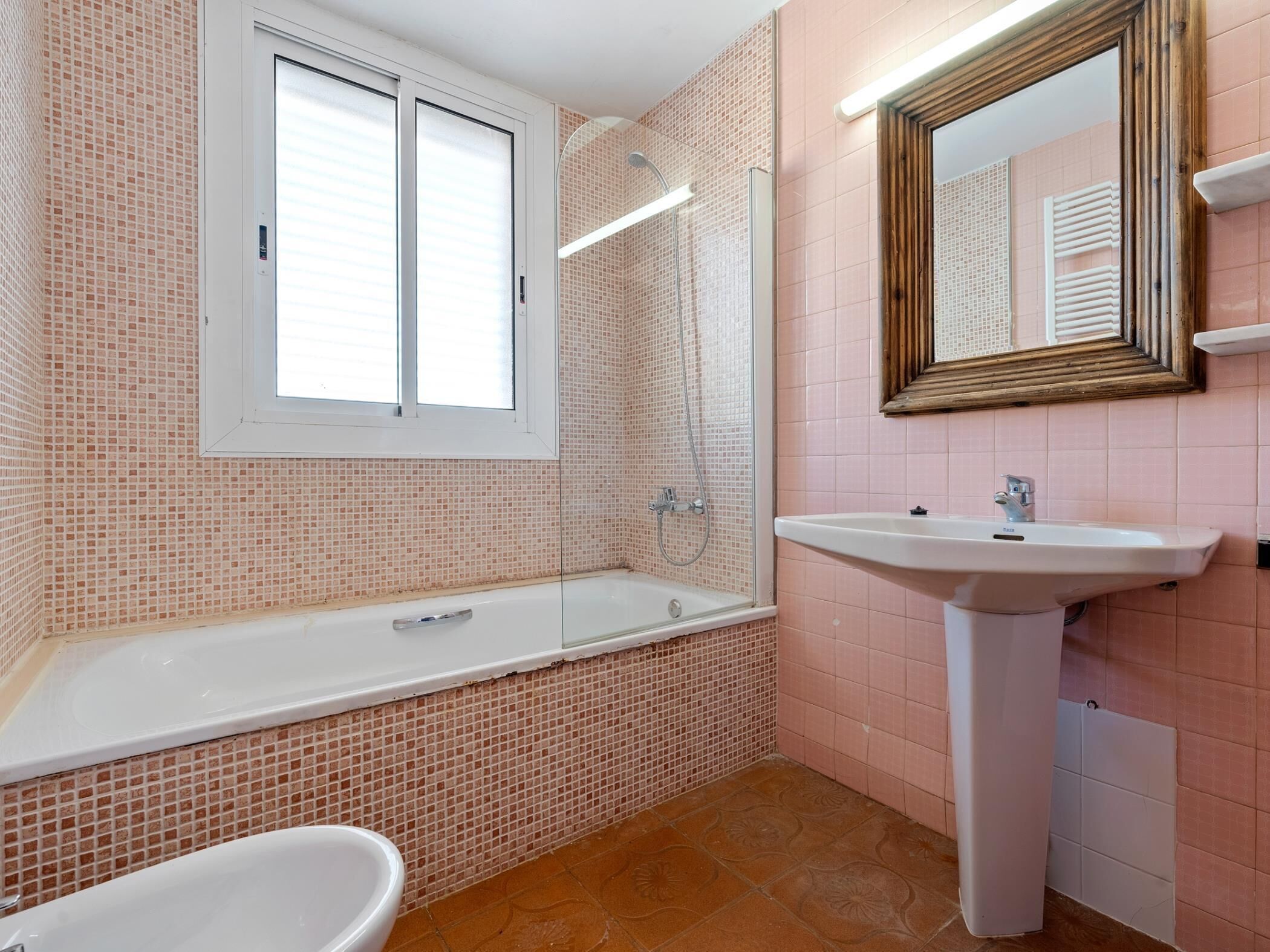 Une salle de bain avec une baignoire, un lavabo et une fenêtre.