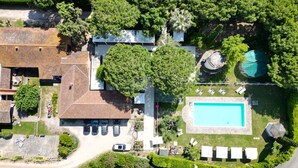 An aerial view of a residential property with a swimming pool, multiple cars, and lush greenery. - Apartment 'Amelia' with Shared Pool, Wi-Fi and Air Conditioning (Grosseto)