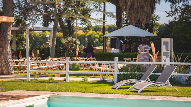 A pool area with lounge chairs, a pergola, and a covered seating area. - Apartment 'Amelia' with Shared Pool, Wi-Fi and Air Conditioning (Grosseto)