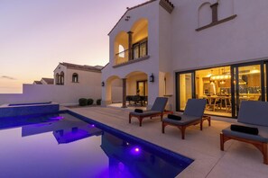 Uma casa moderna com piscina, área de estar externa e um amplo espaço para refeições.