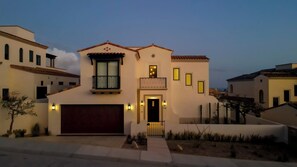 A two-story house with a garage, a balcony, and multiple windows.