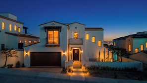 A residential house with a garage, a balcony, and multiple windows.