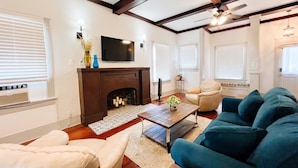 Una sala de estar con chimenea, televisor y sofá.