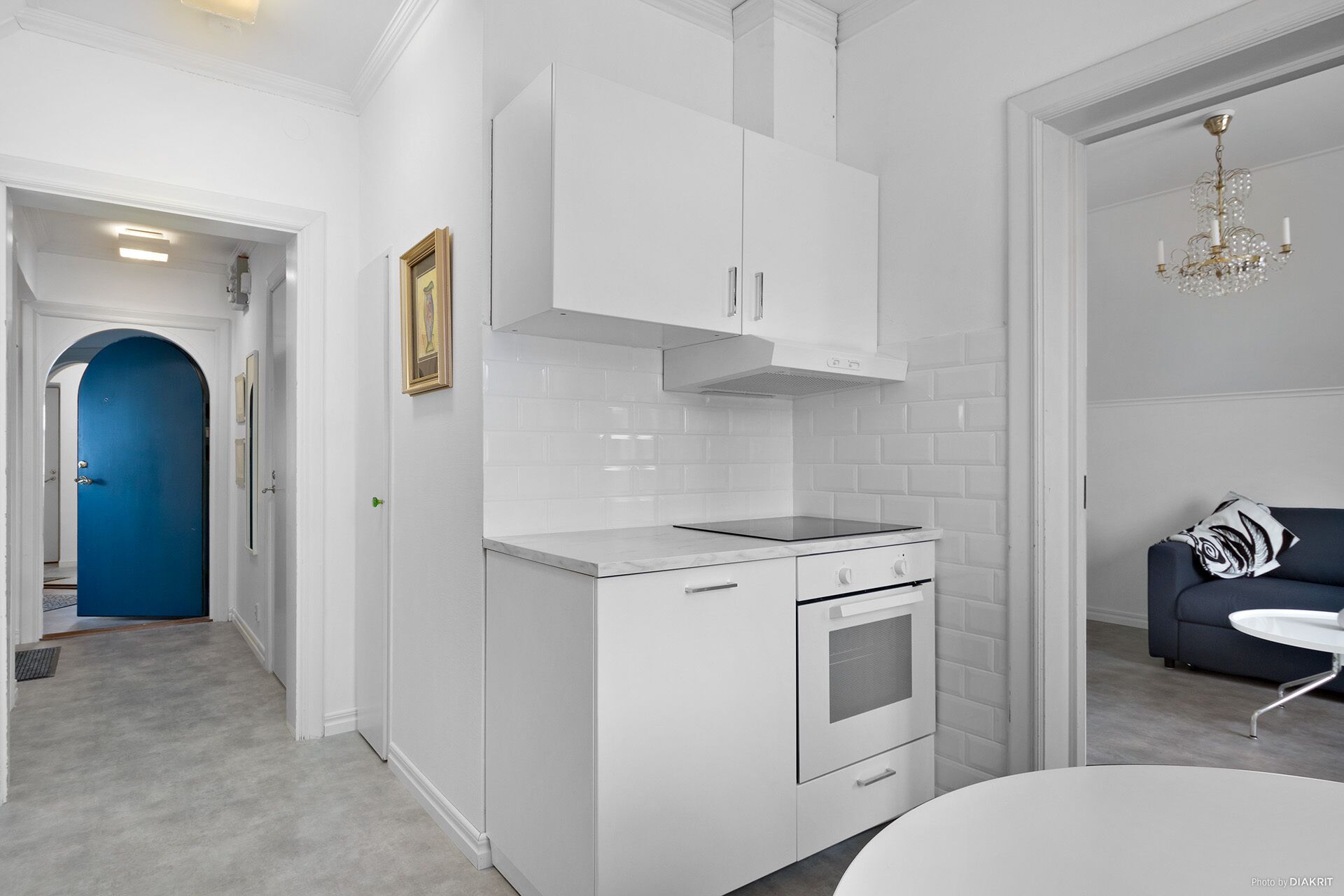 A modern kitchen with white cabinetry, a built-in oven, and a countertop.