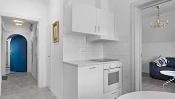 A modern kitchen with white cabinetry, a built-in oven, and a countertop.