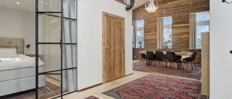 Um interior moderno com uma cama, uma área de refeições e uma escada.