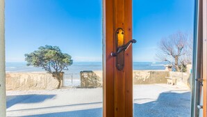 Vista desde una habitación con puerta de madera que da a la playa.
