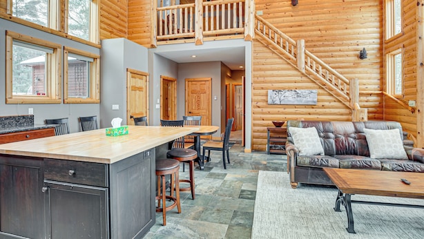 A spacious log cabin interior with a kitchen, dining area, and living room. - Lakefront Gem w/ Dock & Views in Lac Du Flambeau (Lac Du Flambeau)